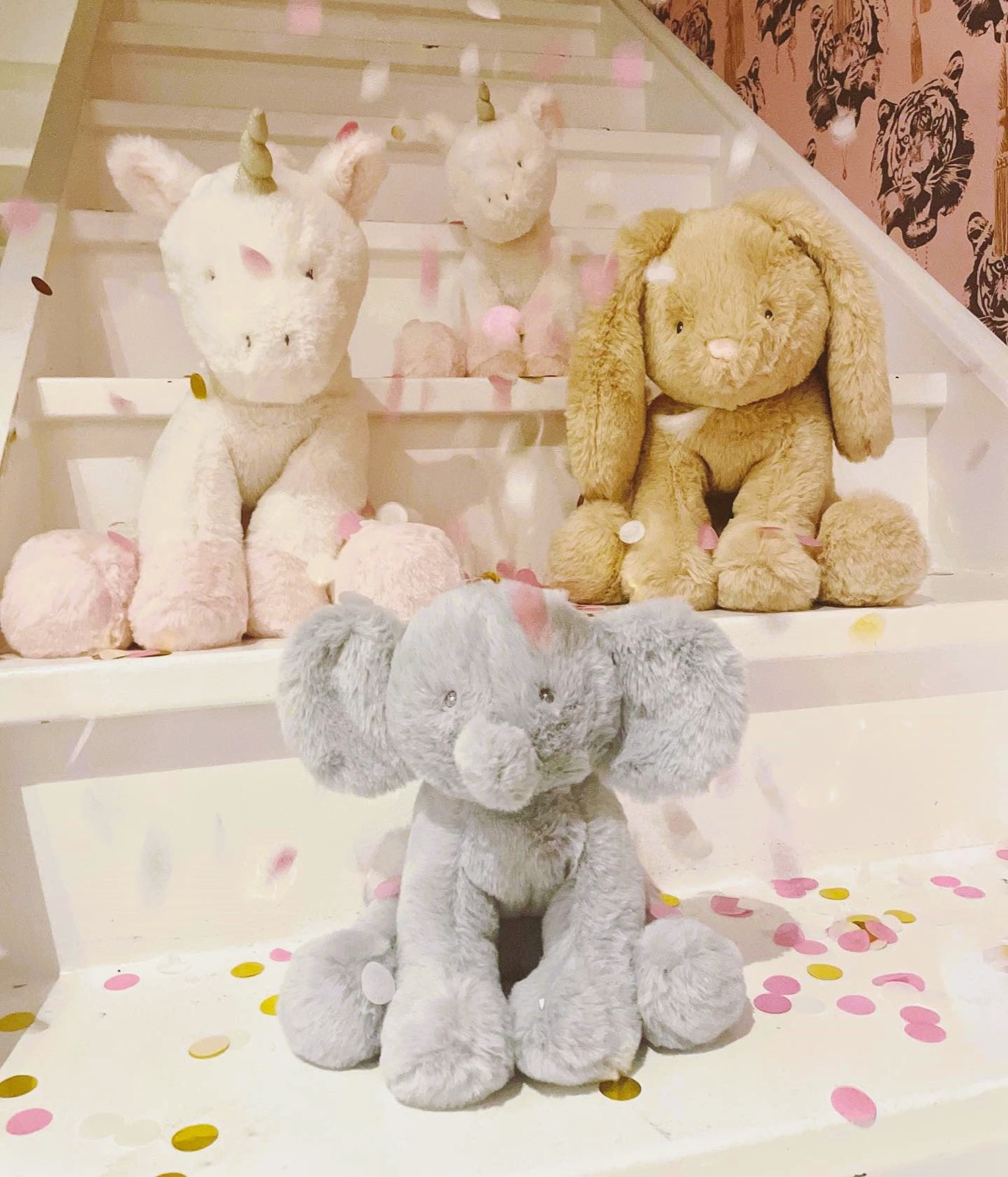 Mjukisdjur från Fresh Kid, enhörning, kanin och elefant, sitter i en trappa med konfetti