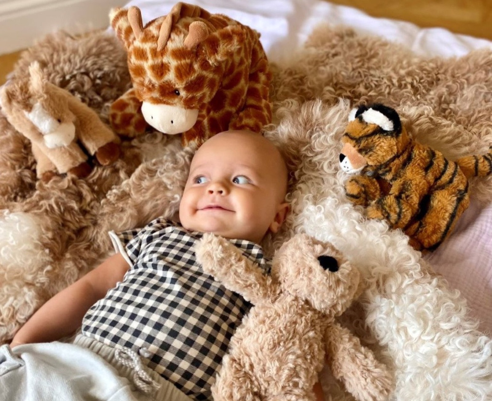 Bebis ligger bland mjukisdjur från Fresh Kid